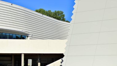 Modern bir teneke binanın minimalist fotoğrafı. Büyük cam vitrinleri var..