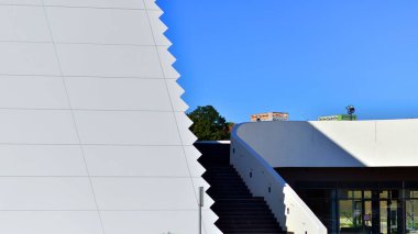 Modern bir teneke binanın minimalist fotoğrafı. Büyük cam vitrinleri var..