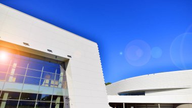 Modern bir teneke binanın minimalist fotoğrafı. Büyük cam vitrinleri var..