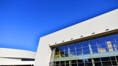 Modern bir teneke binanın minimalist fotoğrafı. Büyük cam vitrinleri var..