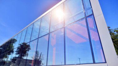 Mimarlık detayları. Güneşli bir günde modern cam bina cephesi. İş geçmişi.