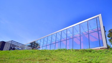 Architecture details. Modern glass building facade in sunny day. Business background.