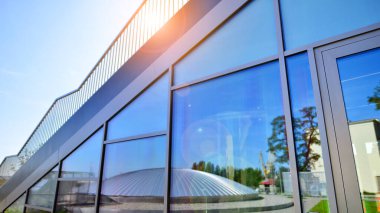 Mimarlık detayları. Güneşli bir günde modern cam bina cephesi. İş geçmişi.