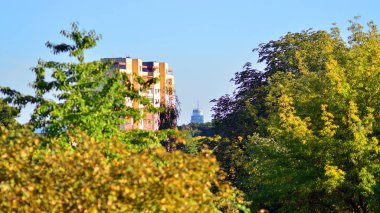 Modern apartman ve yeşil ağaçlar. Ekolojik konut mimarisi. Ağaçların çevresindeki modern bir yerleşim yeri. Ekoloji ve yeşil şehir, kentsel çevre 