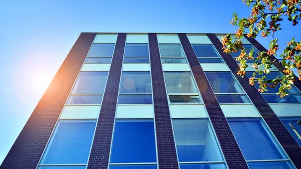 Architecture details. Modern glass building facade in sunny day. Business background.