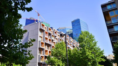 Modern apartman ve yeşil ağaçlar. Ekolojik konut mimarisi. Ağaçların çevresindeki modern bir yerleşim yeri. Ekoloji ve yeşil şehir, kentsel çevre 