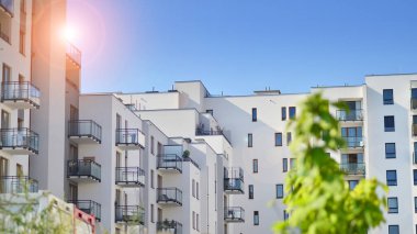 Ağaçların çevresindeki modern bir yerleşim yeri. Ekoloji ve yeşil yaşam şehirde, kentsel çevre kavramı. Modern apartman ve yeşil ağaçlar. Ekolojik konut mimarisi. 