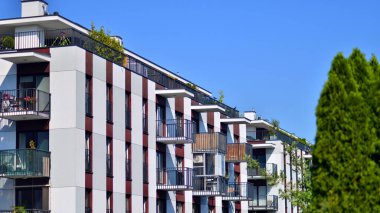 Ağaçların çevresindeki modern bir yerleşim yeri. Ekoloji ve yeşil yaşam şehirde, kentsel çevre kavramı. Modern apartman ve yeşil ağaçlar. Ekolojik konut mimarisi. 