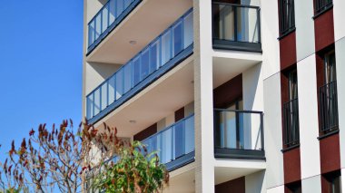 Ağaçların çevresindeki modern bir yerleşim yeri. Ekoloji ve yeşil yaşam şehirde, kentsel çevre kavramı. Modern apartman ve yeşil ağaçlar. Ekolojik konut mimarisi. 