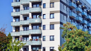 Ağaçların çevresindeki modern bir yerleşim yeri. Ekoloji ve yeşil yaşam şehirde, kentsel çevre kavramı. Modern apartman ve yeşil ağaçlar. Ekolojik konut mimarisi. 