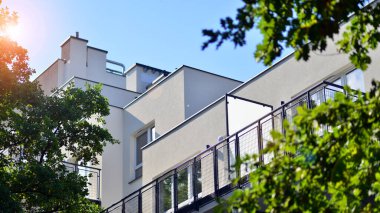 Ağaçların çevresindeki modern bir yerleşim yeri. Ekoloji ve yeşil yaşam şehirde, kentsel çevre kavramı. Modern apartman ve yeşil ağaçlar. Ekolojik konut mimarisi. 