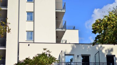 Ağaçların çevresindeki modern bir yerleşim yeri. Ekoloji ve yeşil yaşam şehirde, kentsel çevre kavramı. Modern apartman ve yeşil ağaçlar. Ekolojik konut mimarisi. 