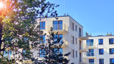 Ağaçların çevresindeki modern bir yerleşim yeri. Ekoloji ve yeşil yaşam şehirde, kentsel çevre kavramı. Modern apartman ve yeşil ağaçlar. Ekolojik konut mimarisi. 