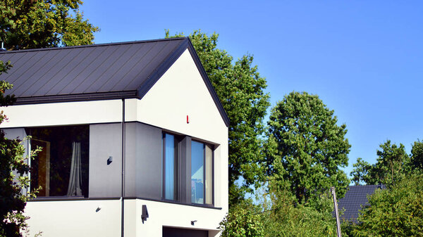 Luxury real estate single family house with modern facade. View during sunny day.