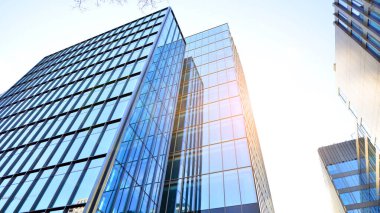 Mavi modern ofis binasına bakıyorum. Alüminyum çerçeveli binanın cam pencereleri.