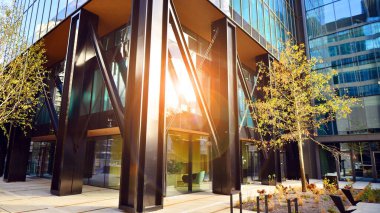 Çelik ve cam. Modern mimari ya da inşaat endüstrisinin konusu. Modern ofis binası cephesi yüksek çelik yapı elemanları ve tam boy pencereler arasında. 