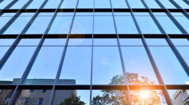 Mavi modern ofis binasına bakıyorum. Alüminyum çerçeveli binanın cam pencereleri.