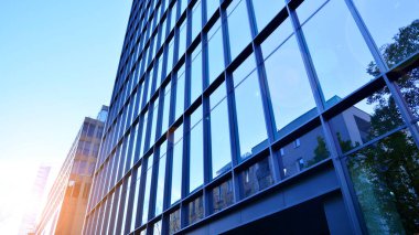 Mavi modern ofis binasına bakıyorum. Alüminyum çerçeveli binanın cam pencereleri.