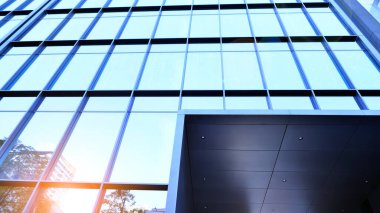 Mavi modern ofis binasına bakıyorum. Alüminyum çerçeveli binanın cam pencereleri.