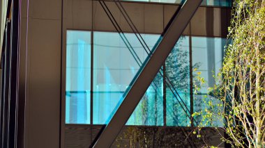 Çelik ve cam. Modern mimari ya da inşaat endüstrisinin konusu. Modern ofis binası cephesi yüksek çelik yapı elemanları ve tam boy pencereler arasında. 