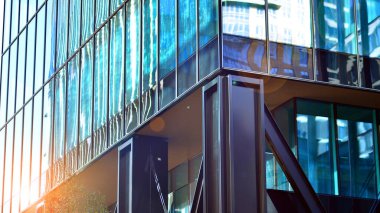 Çelik ve cam. Modern mimari ya da inşaat endüstrisinin konusu. Modern ofis binası cephesi yüksek çelik yapı elemanları ve tam boy pencereler arasında. 