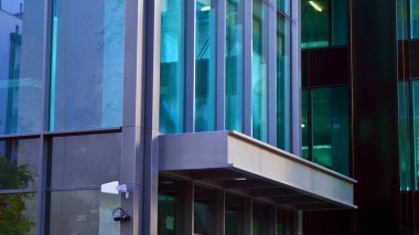 Çelik ve cam. Modern mimari ya da inşaat endüstrisinin konusu. Modern ofis binası cephesi yüksek çelik yapı elemanları ve tam boy pencereler arasında. 
