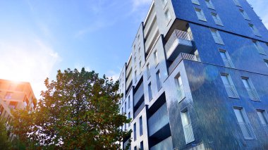 Modern yerleşim alanı. Yeni apartmanın yakınındaki ağaçlar. Doğa dostu lüks gayrimenkul.