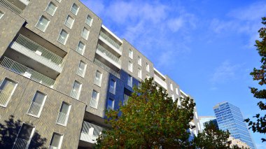 Modern yerleşim alanı. Yeni apartmanın yakınındaki ağaçlar. Doğa dostu lüks gayrimenkul.