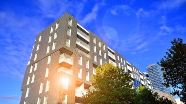 Modern yerleşim alanı. Yeni apartmanın yakınındaki ağaçlar. Doğa dostu lüks gayrimenkul.