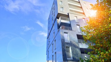 Modern yerleşim alanı. Yeni apartmanın yakınındaki ağaçlar. Doğa dostu lüks gayrimenkul.