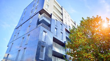 Modern yerleşim alanı. Yeni apartmanın yakınındaki ağaçlar. Doğa dostu lüks gayrimenkul.