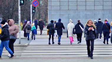 Varşova, Polonya. 29 Aralık 2023. Kalabalık kalabalık trafiğin en yoğun olduğu saatte trafik ışığı zebrasıyla karşıdan karşıya geçiyor. Europa 'da büyük bir şehirde yaşam tarzı.