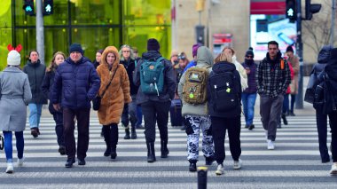 Varşova, Polonya. 29 Aralık 2023. Kalabalık kalabalık trafiğin en yoğun olduğu saatte trafik ışığı zebrasıyla karşıdan karşıya geçiyor. Europa 'da büyük bir şehirde yaşam tarzı.