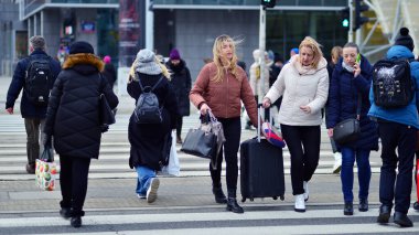 Varşova, Polonya. 29 Aralık 2023. Kalabalık kalabalık trafiğin en yoğun olduğu saatte trafik ışığı zebrasıyla karşıdan karşıya geçiyor. Europa 'da büyük bir şehirde yaşam tarzı.