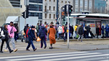 Varşova, Polonya. 29 Aralık 2023. Kalabalık kalabalık trafiğin en yoğun olduğu saatte trafik ışığı zebrasıyla karşıdan karşıya geçiyor. Europa 'da büyük bir şehirde yaşam tarzı.