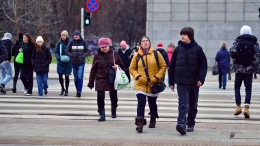 Varşova, Polonya. 29 Aralık 2023. Kalabalık kalabalık trafiğin en yoğun olduğu saatte trafik ışığı zebrasıyla karşıdan karşıya geçiyor. Europa 'da büyük bir şehirde yaşam tarzı.