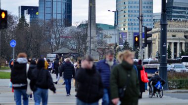 Varşova, Polonya. 29 Aralık 2023. Kalabalık kalabalık trafiğin en yoğun olduğu saatte trafik ışığı zebrasıyla karşıdan karşıya geçiyor. Europa 'da büyük bir şehirde yaşam tarzı.