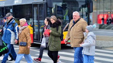 Varşova, Polonya. 29 Aralık 2023. Kalabalık kalabalık trafiğin en yoğun olduğu saatte trafik ışığı zebrasıyla karşıdan karşıya geçiyor. Europa 'da büyük bir şehirde yaşam tarzı.