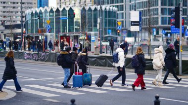 Varşova, Polonya. 29 Aralık 2023. Kalabalık kalabalık trafiğin en yoğun olduğu saatte trafik ışığı zebrasıyla karşıdan karşıya geçiyor. Europa 'da büyük bir şehirde yaşam tarzı.