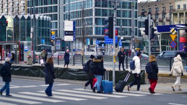 Varşova, Polonya. 29 Aralık 2023. Kalabalık kalabalık trafiğin en yoğun olduğu saatte trafik ışığı zebrasıyla karşıdan karşıya geçiyor. Europa 'da büyük bir şehirde yaşam tarzı.