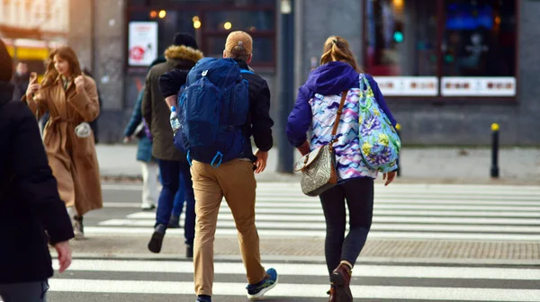 Varşova, Polonya. 29 Aralık 2023. Kalabalık kalabalık trafiğin en yoğun olduğu saatte trafik ışığı zebrasıyla karşıdan karşıya geçiyor. Europa 'da büyük bir şehirde yaşam tarzı.