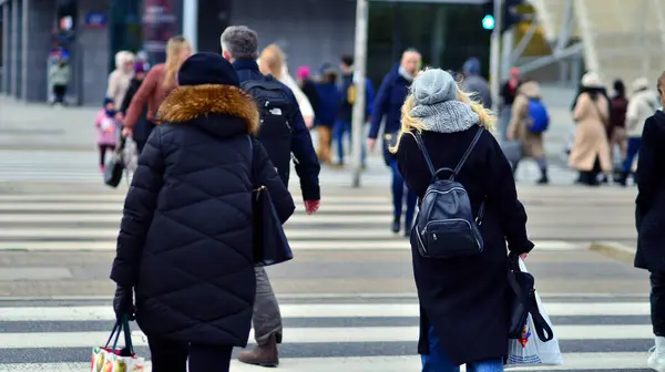 stock image Warsaw, Poland. 29 December 2023. Crowd of people crossing street on traffic light zebra in the city  at rush hour. Lifestyle in a big city in Europa.