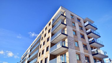Güneşli bir günde modern apartman binası. Dış görünüş, ev cephesi. Modern, yeni ve şık apartmanlı bir yerleşim yeri.. 