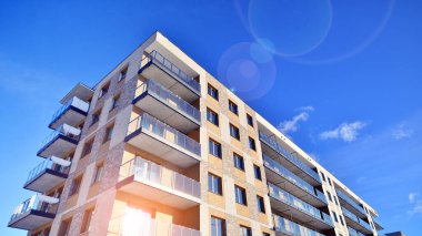 Güneşli bir günde modern apartman binası. Dış görünüş, ev cephesi. Modern, yeni ve şık apartmanlı bir yerleşim yeri.. 