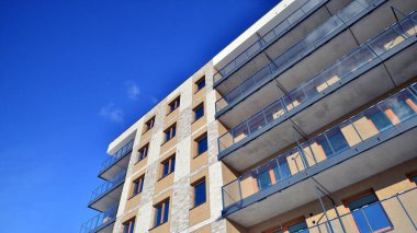 Güneşli bir günde modern apartman binası. Dış görünüş, ev cephesi. Modern, yeni ve şık apartmanlı bir yerleşim yeri.. 