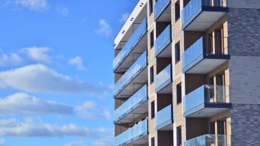 Güneşli bir günde modern apartman binası. Dış görünüş, ev cephesi. Modern, yeni ve şık apartmanlı bir yerleşim yeri.. 