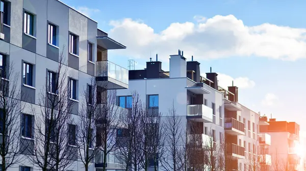 Güneşli bir günde modern apartman binası. Dış görünüş, ev cephesi. Modern, yeni ve şık apartmanlı bir yerleşim yeri.. 