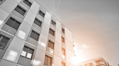 Pencereleri ve balkonları olan bir binanın ön cephesi. Güneşli bir günde modern apartman binaları. Modern bir apartmanın ön cephesi. Siyah ve beyaz.