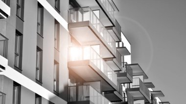 Pencereleri ve balkonları olan bir binanın ön cephesi. Güneşli bir günde modern apartman binaları. Modern bir apartmanın ön cephesi. Siyah ve beyaz.