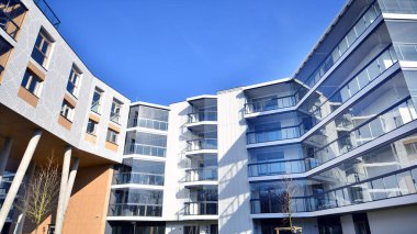 Eşsiz bir mimari çözümü olan bir apartman. Beyaz cepheli ve yüksek beton sütunların üzerinde duran modern bir yerleşim yeri..